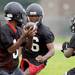 Members of the Ypsilanti Community High School football team practice in the rain at the school on Monday, August 12, 2013. Melanie Maxwell | AnnArbor.com